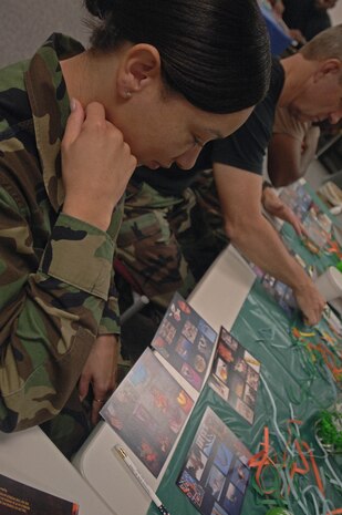 Tech. Sgt. Caroline Deal, 437th Airlift Wing Judge Advocate assistant NCOIC claims, looks over the Four  Lenses cards trying to pick out the one that is most appealing to her.  (U.S. Air Force photo/Staff Sgt. April Quintanilla)