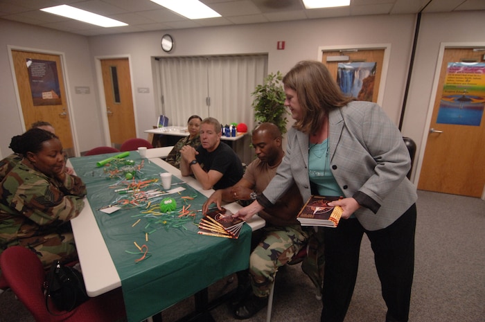 Mrs. Betsy Crump, 437th Mission Support Group relocation assistance manager, passes out Four Lenses books to members of 437th Airlift Wing Staff during Wingman Day Nov. 2 at the Family Readiness Center. (U.S. Air Force photo/Staff Sgt. April Quintanilla)