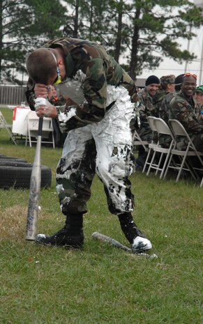 Senior Airman Frederick Shay, 315th Maintenance Squadron, spins in a circle with his forehead on a bat before heading to the "grog bowl" during the combined 437th and 315th Maintenance Squadrons? "Combat Dining Out," Nov. 2 at the base picnic grounds. (U.S. Air Force photo/Staff Sgt. Jennifer Arredondo)