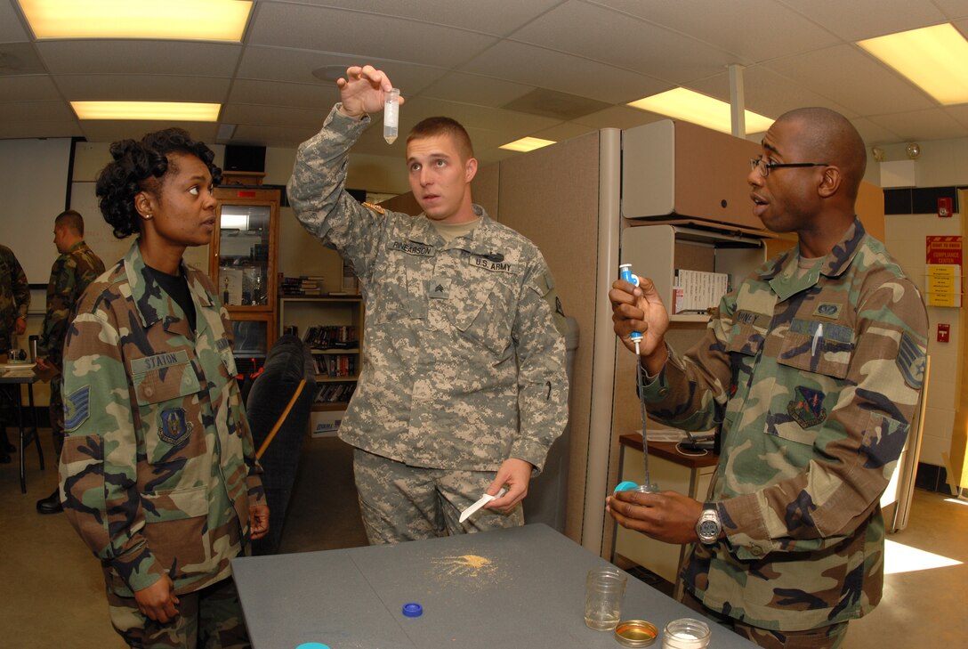 Instructor Sgt. Justin C. Rinearson,  61st CST, center, demonstrates the amount, substance and procedure for testing various chemical and toxic agents to Tech. Sgt. Angela Staton, 436th Civil Engineer Squadron, left, and Staff Sgt. Kimani Cadney, 159th Fighter Wing, during an emergency management training course at the North Dakota Air National Guard Regional Training Site, Fargo, N.D., Sept. 12. (U.S. Air Force photo by Senior Master Sgt. David H. Lipp)