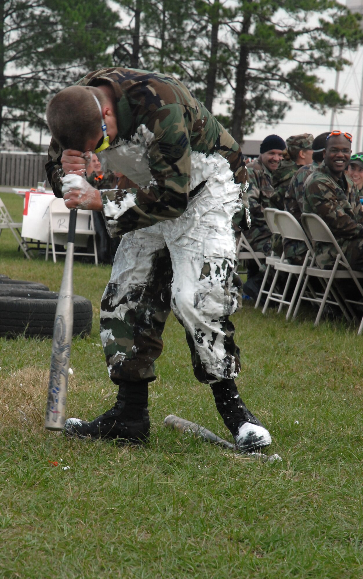 Senior Airman Frederick Shay, 315th Maintenance Squadron, spins in a circle with his forehead on a bat before heading to the "grog bowl" during the combined 437th and 315th Maintenance Squadron's "Combat Dining Out," Nov. 2 at the base picnic grounds (U.S. Air Force photo/Staff Sgt. Jennifer Arredondo)   