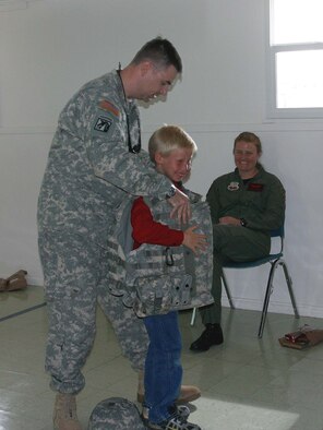 Capt. Todd Haley, the 388th Fighter Wing's U.S. Army Ground Liaison officer, lets 10-year-old Chris Reil try on his gear in Callao, Utah, while briefing about the JTACs.
