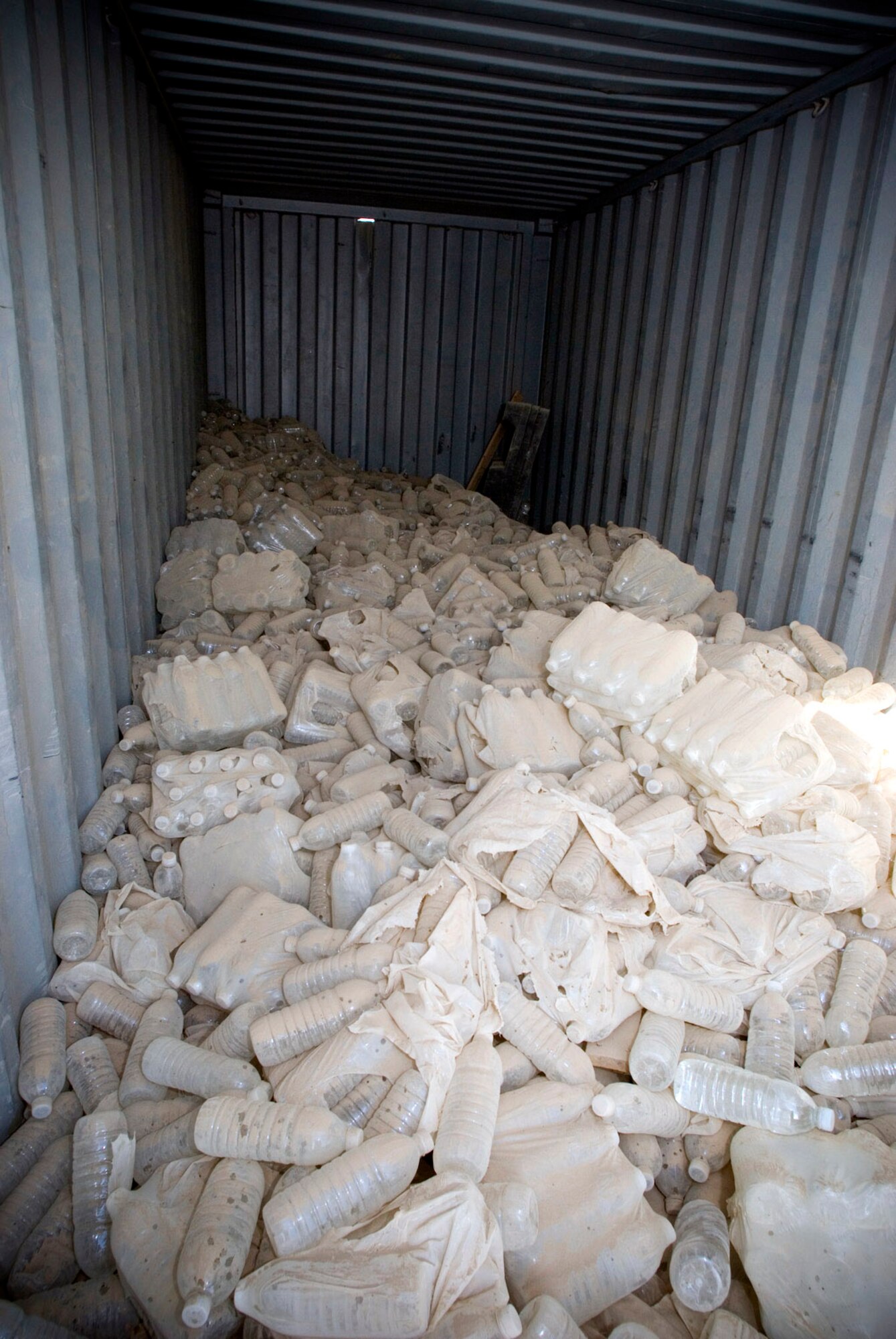 Bottled water recovered by Material Recovery Team III with the 732nd Expeditionary Logistics Readiness Squadron are placed inside a container express Oct. 19 at Camp Corregidor, Iraq. Serviceable assets recovered from the container express are inventoried and redistributed to Army units throughout Iraq. Airmen of various career fields volunteer to augment the Army in nontraditional "in-lieu-of" taskings for up to a year. (U.S. Air Force photo/Master Sgt. John Nimmo Sr.) 

