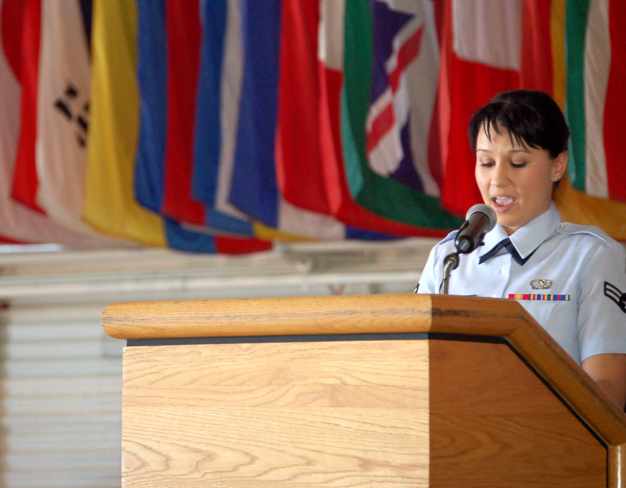Airman 1st Class Olga Bilobol speaks to the crowd about her new citizenship at a naturalization ceremony in the Air Force Thunderbirds' Air Demonstration Squadron hangar Nov. 6 at Nellis Air Force Base, Nev. Airman Bilobol was one of 33 military members to participate in the event, which is the last step in the process of becoming an American citizen. The new citizens included representatives from all the branches of the military. The event was part of the base's Heritage to Horizons celebration of the Air Force's 60th Anniversary.(U.S. Air Force photo/Staff Sgt. Jeremy Larlee) 
