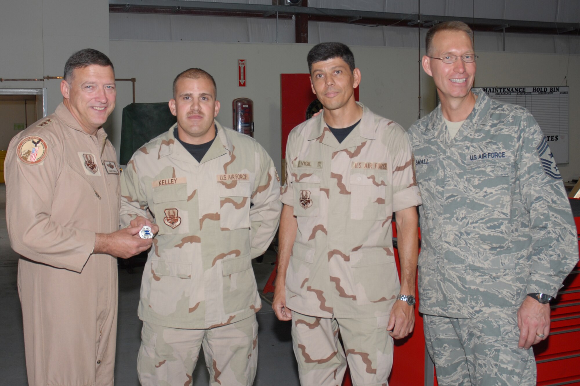 Lieutenant Gen. Gary L. North, commander, 9th Air Force and U.S. Central Command Air Force, recognizes Tech. Sgt. Michael J. Kelley, 379th Expeditionary Maintenance Squadron AGE flight deployed from Dyess AFB, Texas, for superior performance during a visit to Southwest Asia Oct. 27. General North travels to many forward-operating locations to spend time with deployed Airmen. (U.S. Air Force photo by Staff Sergeant Douglas C. Olsen)