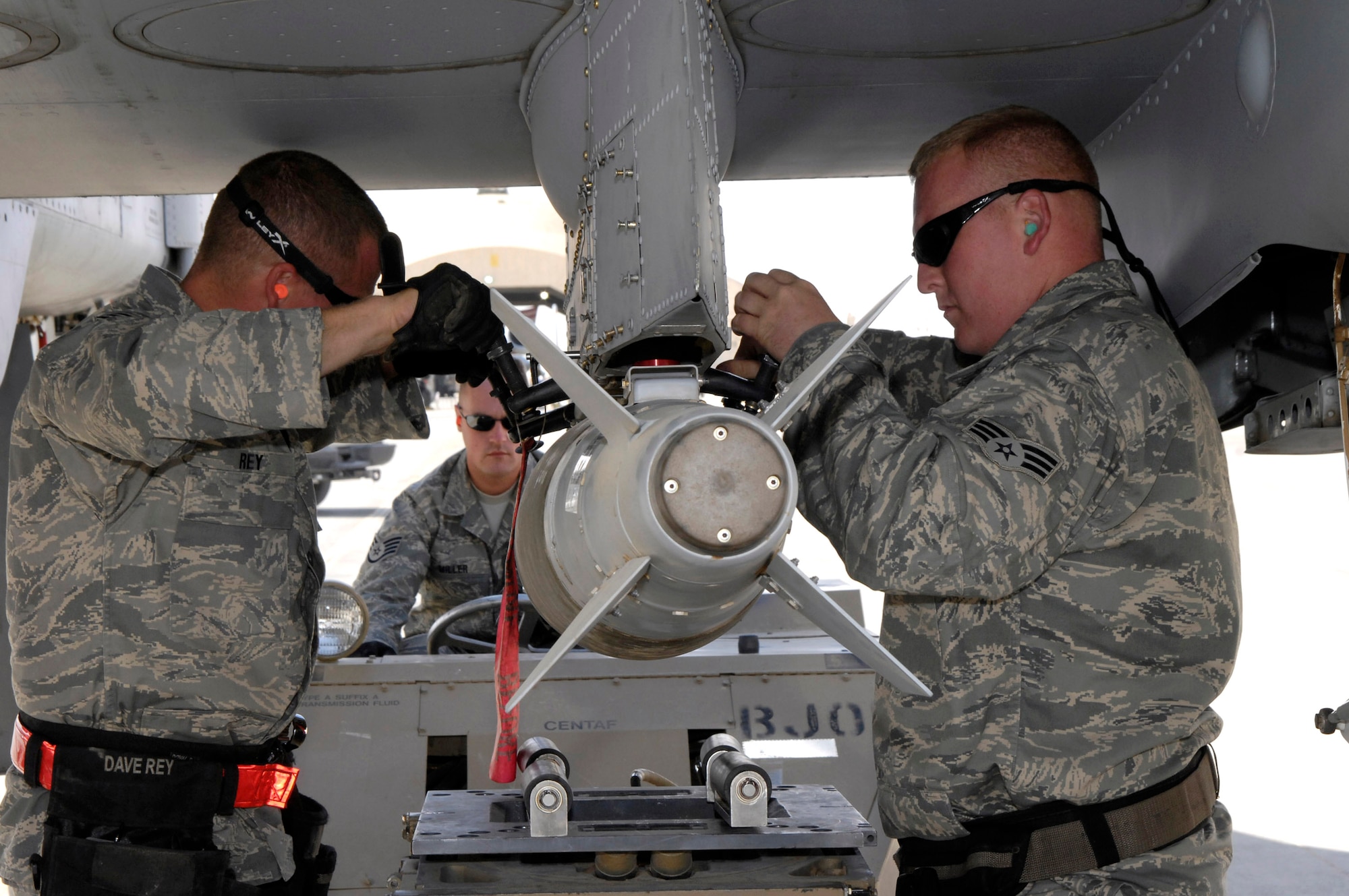 Senior Airman Larry Lewis, Staff Sgt. Chris Miller, and Tech. Sgt. David Rey load a Joint Directed Attack Munition to an A-10 Thunderbolt II Oct. 27 at Al Asad Air Base, Iraq. The A-10C's are assigned to the 104th Expeditionary Fighter Squadron, which is made up primarily of members from the 175th Maryland Air National Guard. Airman Lewis and Sergeants Miller and Rey are Maryland Air National Guard weapons loaders. The 104th EFS is the first unit to use the C-model A-10 in a combat zone. Its upgrades have made air power more efficient and have streamlined the close-air-support mission. (U.S. Air Force photo/Staff Sgt Angelique Perez)
