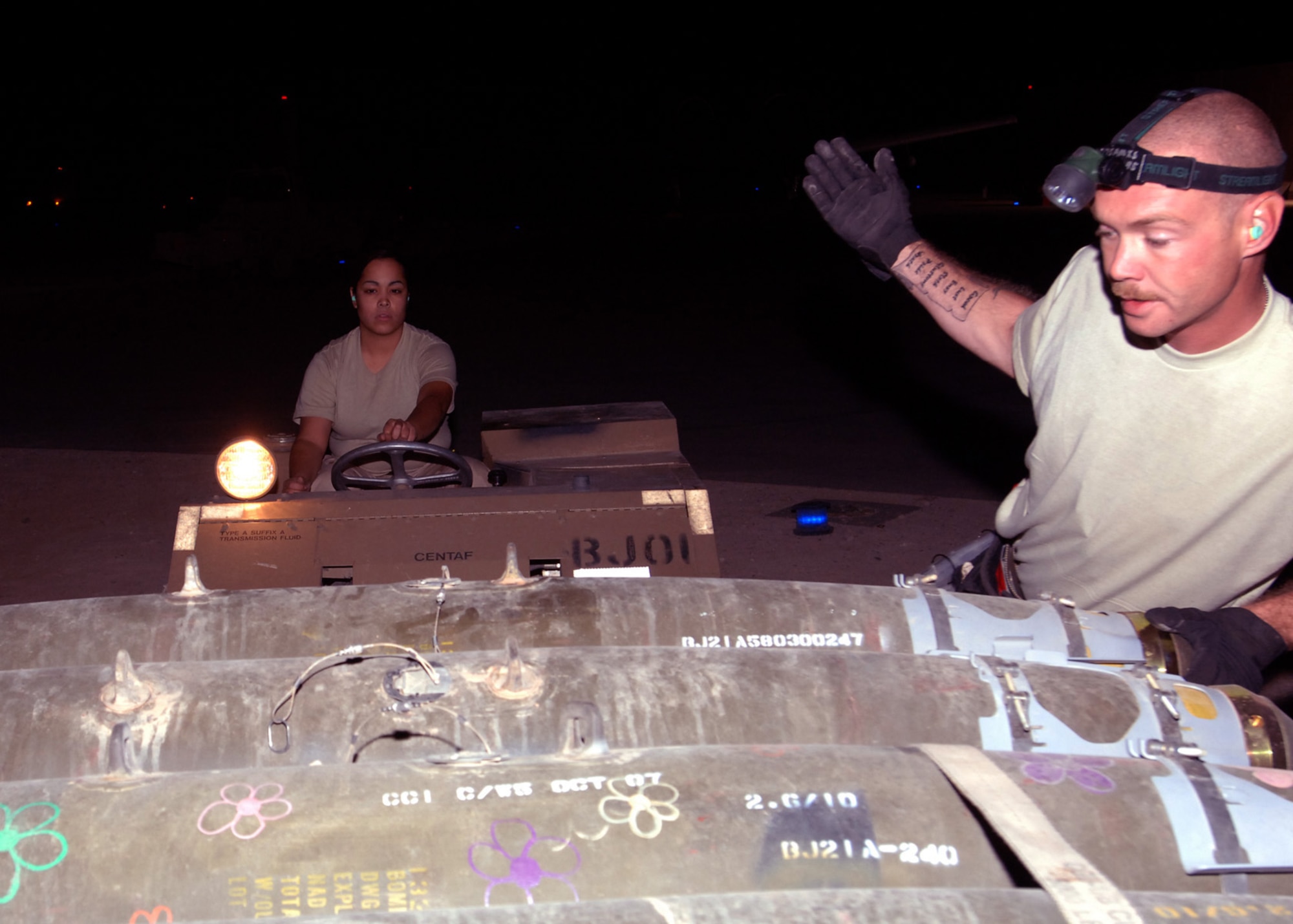 AL ASAD AIR BASE, Iraq -- Tech. Sgt. Frank Williams guides an MJ-1 “jammer” vehicle operated by Senior Airman Anna Rodriguez to a pallet of Joint Direct Attack Munitions here. The Airmen are both weapons loaders for the 438th Air Expeditionary Group. The unit’s newly upgraded A-10C Thunderbolt IIs are the first to fly in combat. Sergeant Williams and Airman Rodriguez are deployed from the 175th Wing, Maryland Air National Guard, Baltimore. (U.S. Air Force photo/Tech. Sgt. D. Clare)