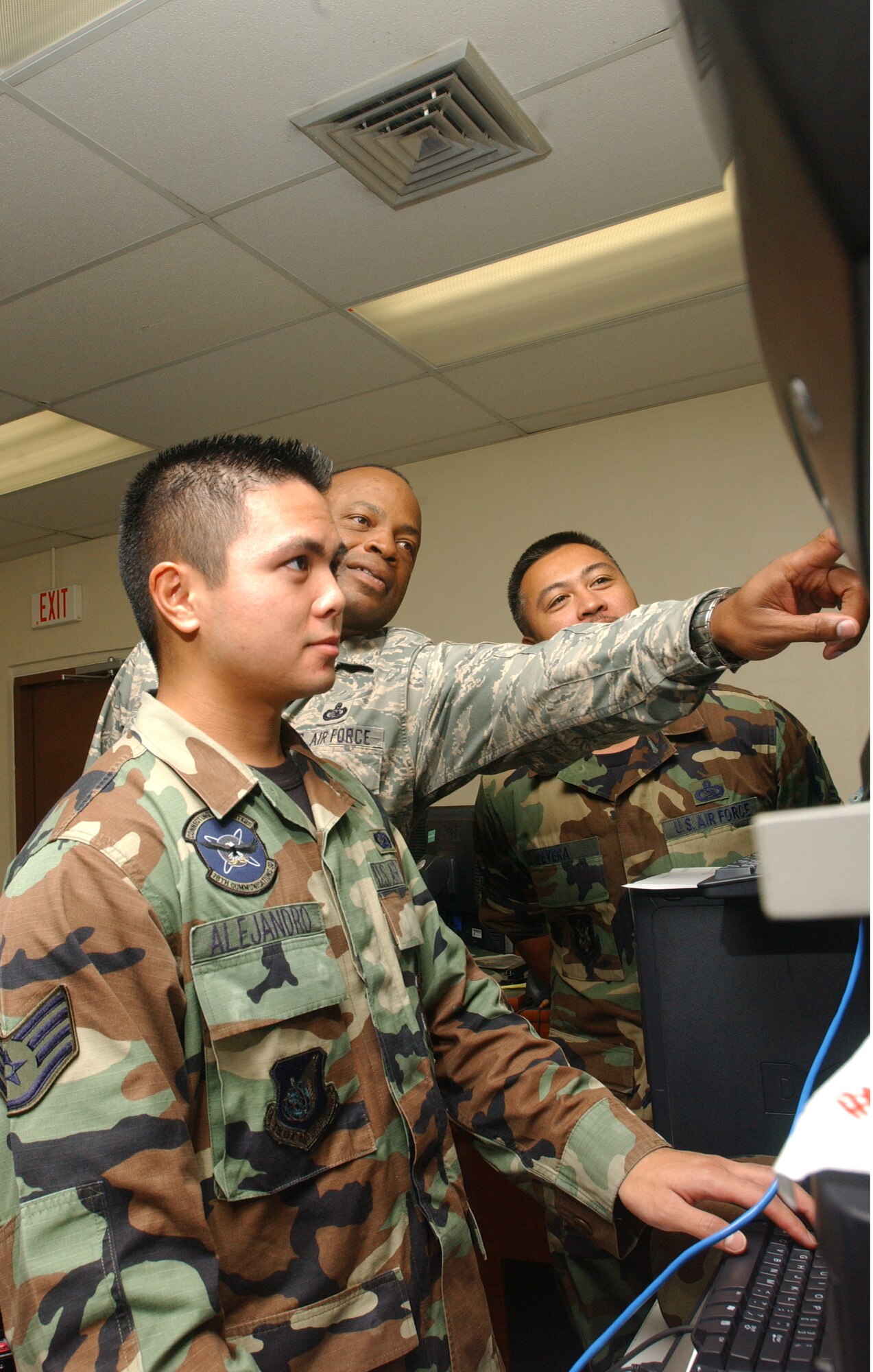 Master Sgt. Rickey Bryant (center), Senior Master Sgt. Vincent DeVera (right) and Staff Sgt Matthew Alejandro troubleshoot a component of the communications network they’re entrusted to protect.  These senior non-commissioned officers, with more than 40-years of hard won experience between them, are actively passing along that critical knowledge to the future of our Air Force. The U.S. military is unique in that senior ranking personnel are expected to have an active hand in training what will eventually become their replacements. (Air Force photo/Senior Airman Brian Kimball)