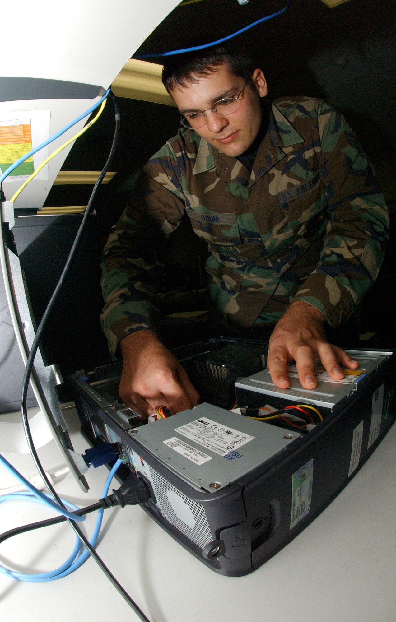 Senior Airman Jonathan Odum, 36th Communications Squadron, fixes a computer that will eventually go on the Andersen computer network. Airman Odum, deployed here as an Air Force Reservist from Ohio, is part of a special group of Airmen that are charged with the critical task of protecting Andersen’s cyberspace against intruders.  Airman Odum and his fellow communications specialists operate under the “best defense is an aggressive offense” strategy and take steps every day to make the local communications networks here a hard target. (Air Force photo/Senior Airman Brian Kimball)