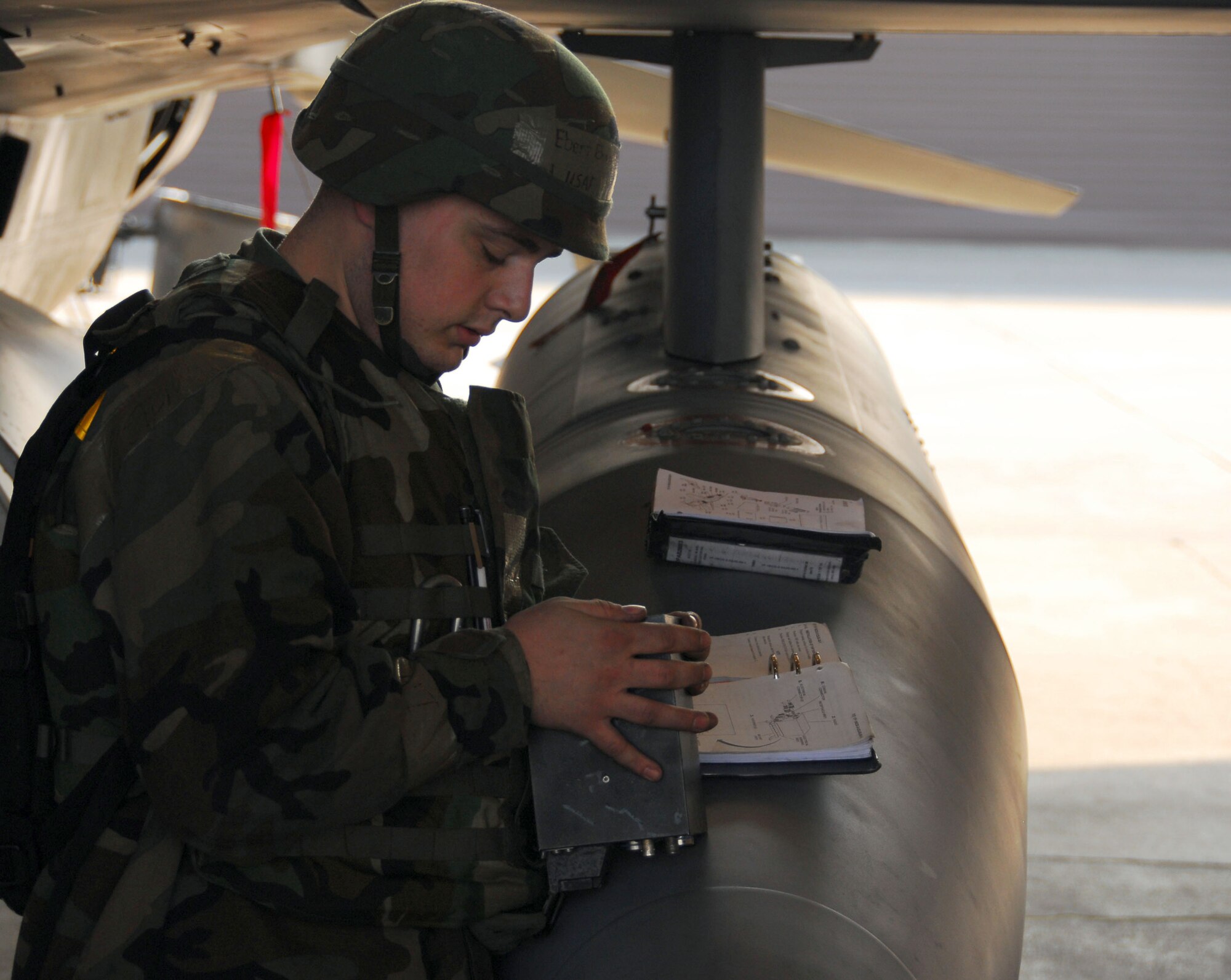 OSAN AIR BASE, Republic of Korea -- Senior Airman Brandon Ebert, 51st Aircraft Maintenance Squadron, Avionics Technician, refers to his technical order (T.O.) before installing a very high frequency receiver transmitter (VHF RT) on an F-16. During a peninsula wide exercise at Osan AB, South Korea.  The exercise Beverly Bulldog 08-01 scenarios test Team Osan's ability to defend the base and conduct daily operations in a combat environment.  (U.S. Air Force Photo by Staff Sgt Ronnie Hill) (Released)   