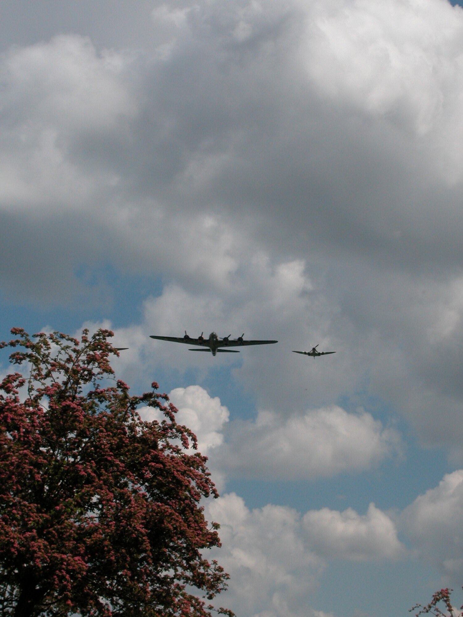 A P-51 Mustang (r) escorts the B-17 Sally B over the cemetery’s annual memorial ceremony. Sally B is the only flying-capable Flying Fortress in the United Kingdom. (U.S. Air Force photo by Senior Master Sgt. Matt Proietti/452 AMW)