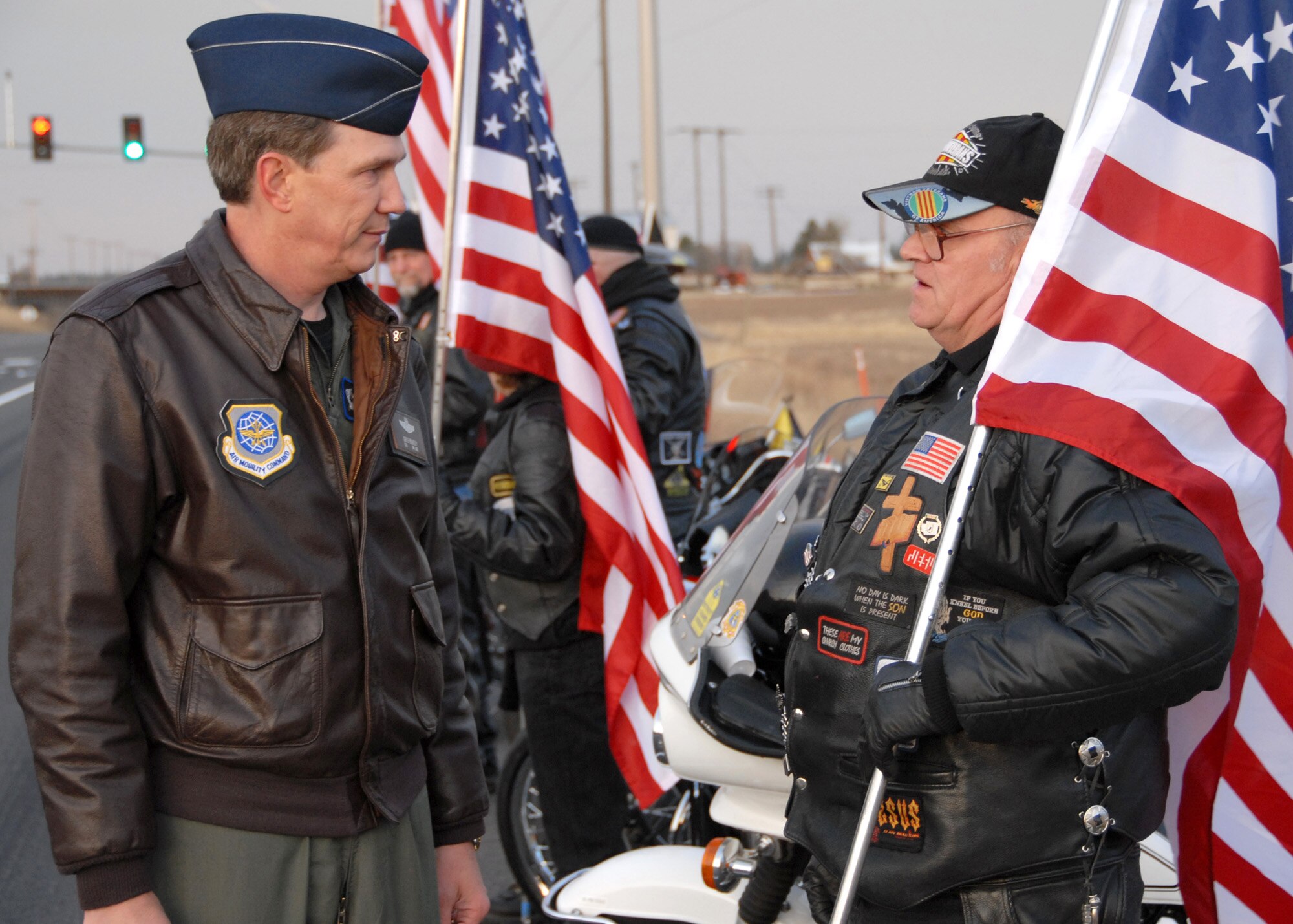 FAIRCHILD AIR FORCE BASE, Wash. – Col. Gregory Bulkley, 141st Air Refueling Wing commander, is greeted by a member of Operation Spokane Heroes outside the Fairchild main gate Nov. 3. OSH arrived at the gate waving American flags and welcoming signs to greet the Airmen reporting for duty. (U.S. Air Force photo / Senior Airman Anthony Ennamorato)