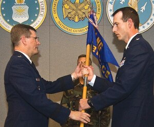 Brig. Gen. Richard Prosek receives the 231st Combat Communications Squadron Guidon from Lt. Col. Robert D. Price, 231 CCS commander, during the inactivation ceremony. The 231 CCS's mission was to provide rapidly mobile, highly secure, state-of-the-art communications  services to the United States of America and the District of Columbia. 