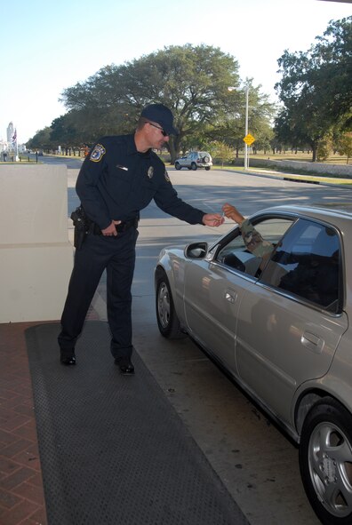 Shawn Vinglass, a DoD security guard, checks incoming visitors for identification at Randolph AFB. (U.S. Air Force photo by Steve White)