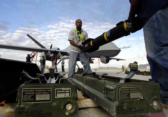 AFGHANISTAN -- General Atomics contractors Alexander Holcomb and Darryl France off-load an AGM-114 Hellfire missile from a fully armed MQ-9 Reaper after landing on an Afghanistan runway Nov. 4, 2007.  (U.S. Air Force photo/Staff Sgt. Brian Ferguson)