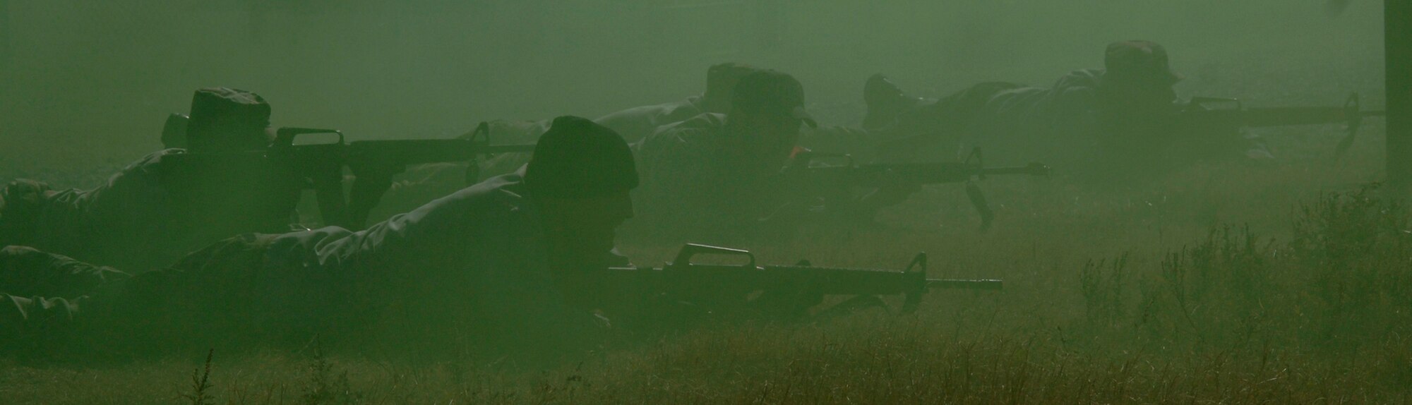 MCCONNELL AIR FORCE BASE, Kan. -- Team Alpha aggressors are laying down cover fire for Team Bravo to run towards the Alert Facility Bldg. 978 while green smoke covers their approach during the Injured Walker exercise Nov. 06. Injured Walker exercise tests the wing’s ability to survive and operate in hostile situations. (Photo by Airman 1st Class Roy Lynch) 