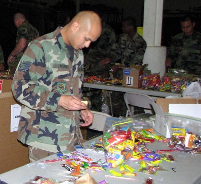 Staff Sgt. Jonathan Lacson, 15th Air Mobility Operations Squadron, sorts candy for Operation Candy Drop at Hangar P-1 Nov. 2. Sergeant Lacson was one of 45 volunteers who collected more than 3,400 pounds of candy that will be distributed throughout Southwest Asia. Seven deployed locations will receive the latest shipments. (U.S. Air Force photo)