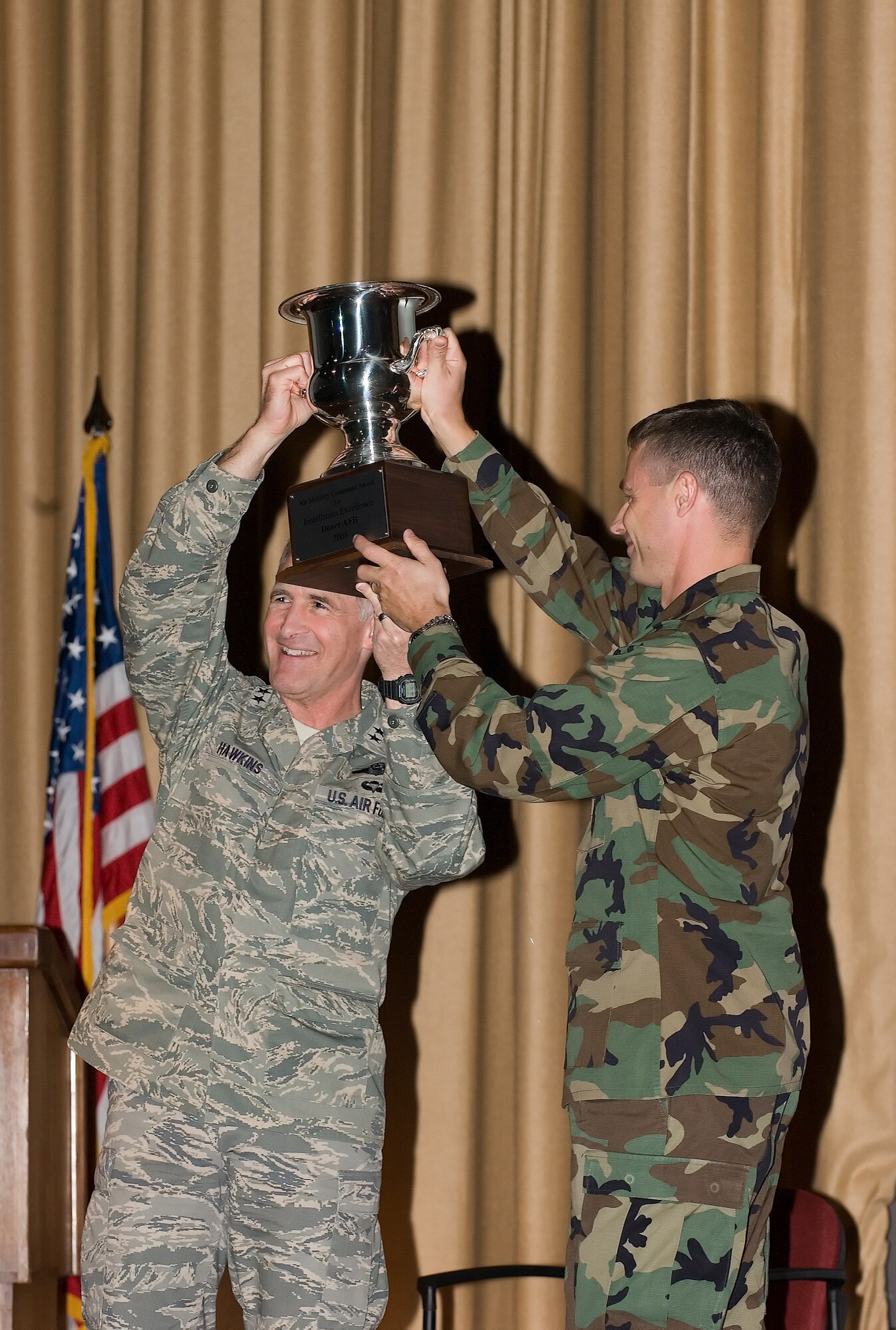 Maj. Gen James Hawkins, 18th Air Force commander, presents Col. Steven Harrison, 436th Airliftwing commander, a trophy on behalf of Gen. Arthur Lichte, Air Mobility Command commander, for the base’s selection as the AMC Commander in Chief’s Installation Excellence Award winner at a victory rally in the Base Theater. (U.S. Air Force photo/Jason Minto)                      