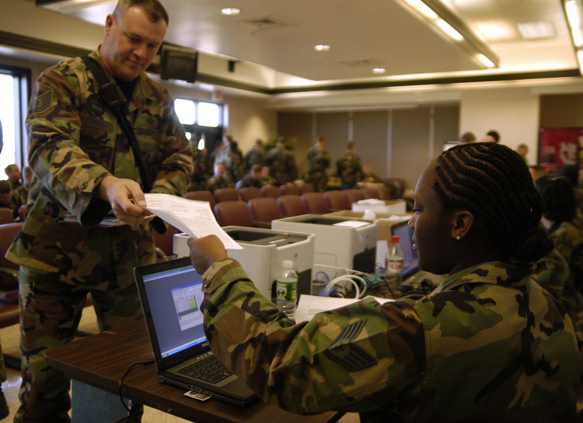 Tech. Sgt. Michael Routh, 436th Civil Engineer Squadron fire department station chief, hands his papers to Staff Sgt. Uzather Larmond, 436th Medical Group NCO in-charge of force health,  during the deployment exercise Nov. 2. (U.S. Air Force photo/Airman Shen-Chia Chu)                                    