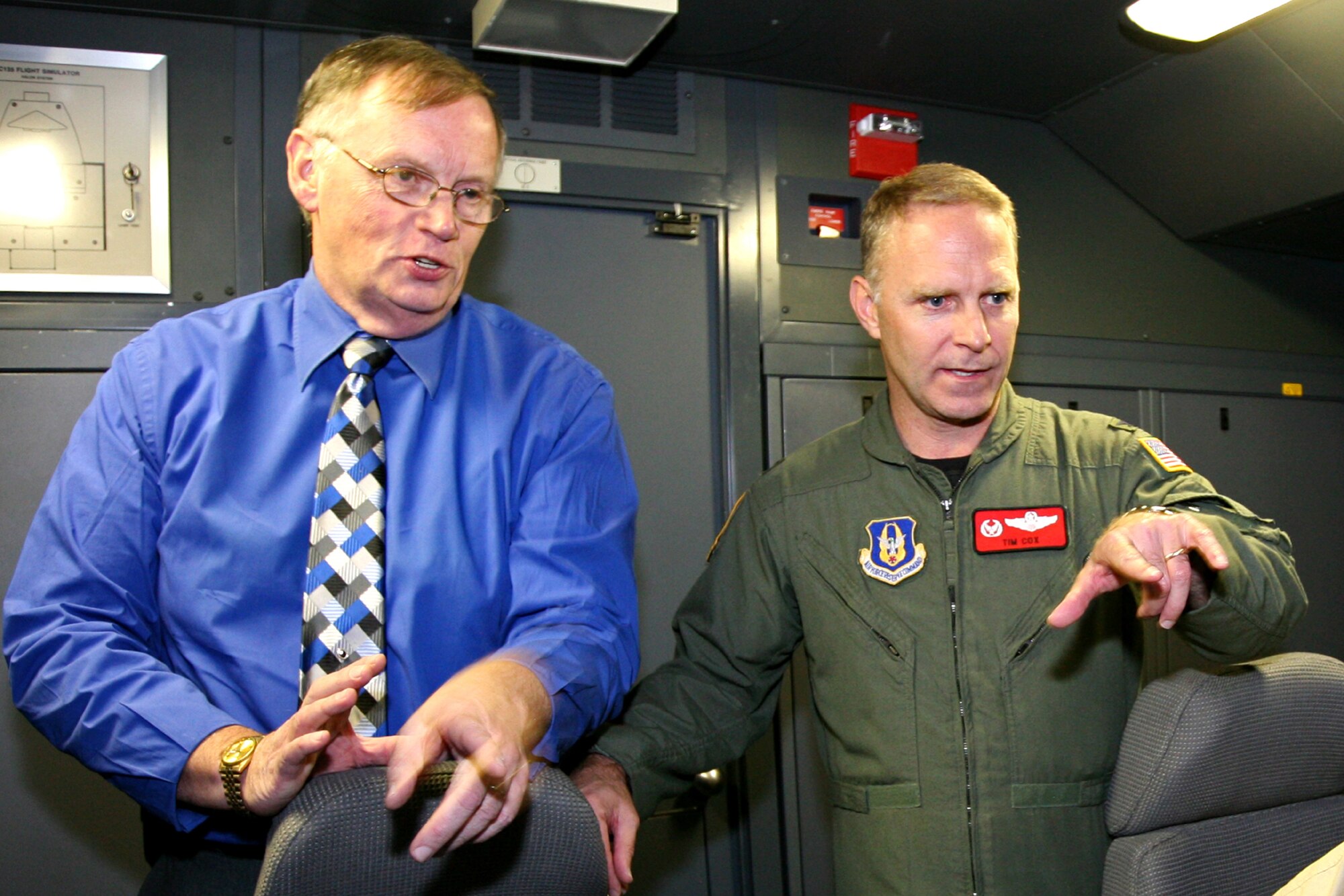 GRISSOM AIR RESERVE BASE, Ind.-- Donald Fogg, a Flight Safety Services Corporation  pilot instructor for the Grissom KC-135 training simulator, left, discusses some of the features in the training simulator with Col. Tim Cox, the 434th Air Refueling Wing vice commander, during the Grissom Community Council visit during November's UTA. (U.S. Air Force/SrA. Omar Delacruz)