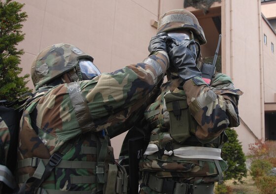 OSAN AIR BASE, Republic of Korea --  Airmen conduct buddy checks while getting into Mission Oriented Protective Posture 4 here Nov. 6. Beverly Bulldog 08-01, a week-long peninsula-wide exercise, tests the readiness of and provides chemical warfare training to military members assigned to the region.  (U.S. Air Force photo by Senior Master Sgt. Marvin Krause)  