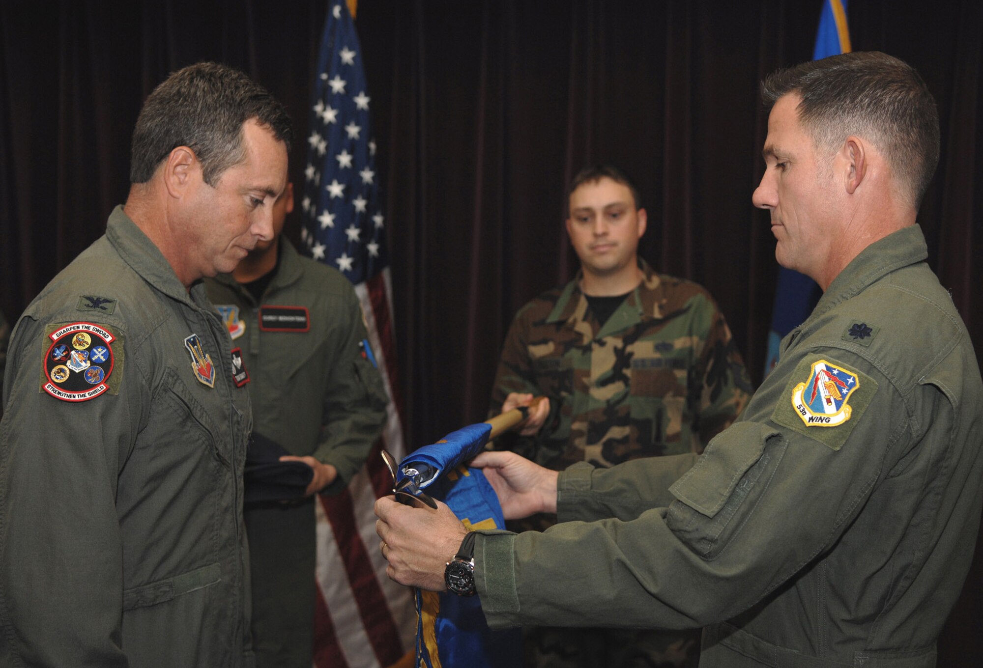 Col. Thomas Berghoff, 53d Test Management Group commander, from the 53rd Wing, Eglin Air Force Base, Fla., watches as Lt. Col. Robert Tomasino unravels a new flag representing Detachment 2's activation here Nov. 6. Colonel Tomasino is the first commander for the newly formed Det. 2, 53d TMG. The detachment determines effectiveness and suitability of new weapon systems and develops future combat employment techniques. The 53d TMG also maintains computer systems critical to electronic warfare software and is responsible for worldwide simulator certification for 176 aircrew training devices. (U.S. Air Force photo/ Airman 1st Class Jessica M. Snow)
