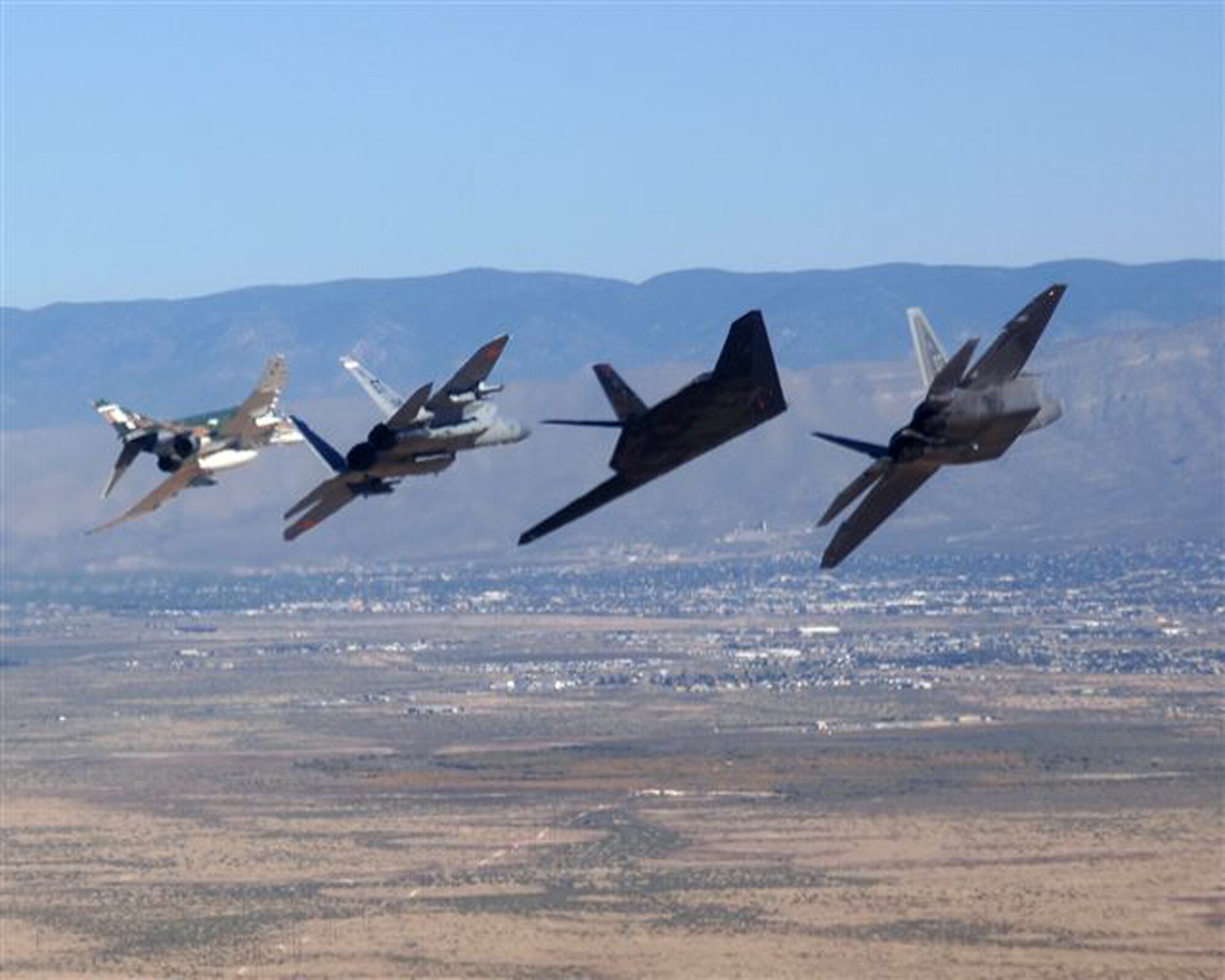 The heritage flight aircraft bank left during its exhibition over Holloman Air Force Base, NM during the Holloman Air and Space Expo on October 27.  The F-4 Phantom was from the 82nd Aerial Targets Squadron Det. 1.  The heritage flight also consisted of an F-15 Eagle, an F-117 Nighthawk and an F-22 Raptor from the 422nd Test and Evaluation Squadron.    (U.S. Air Force photo)
