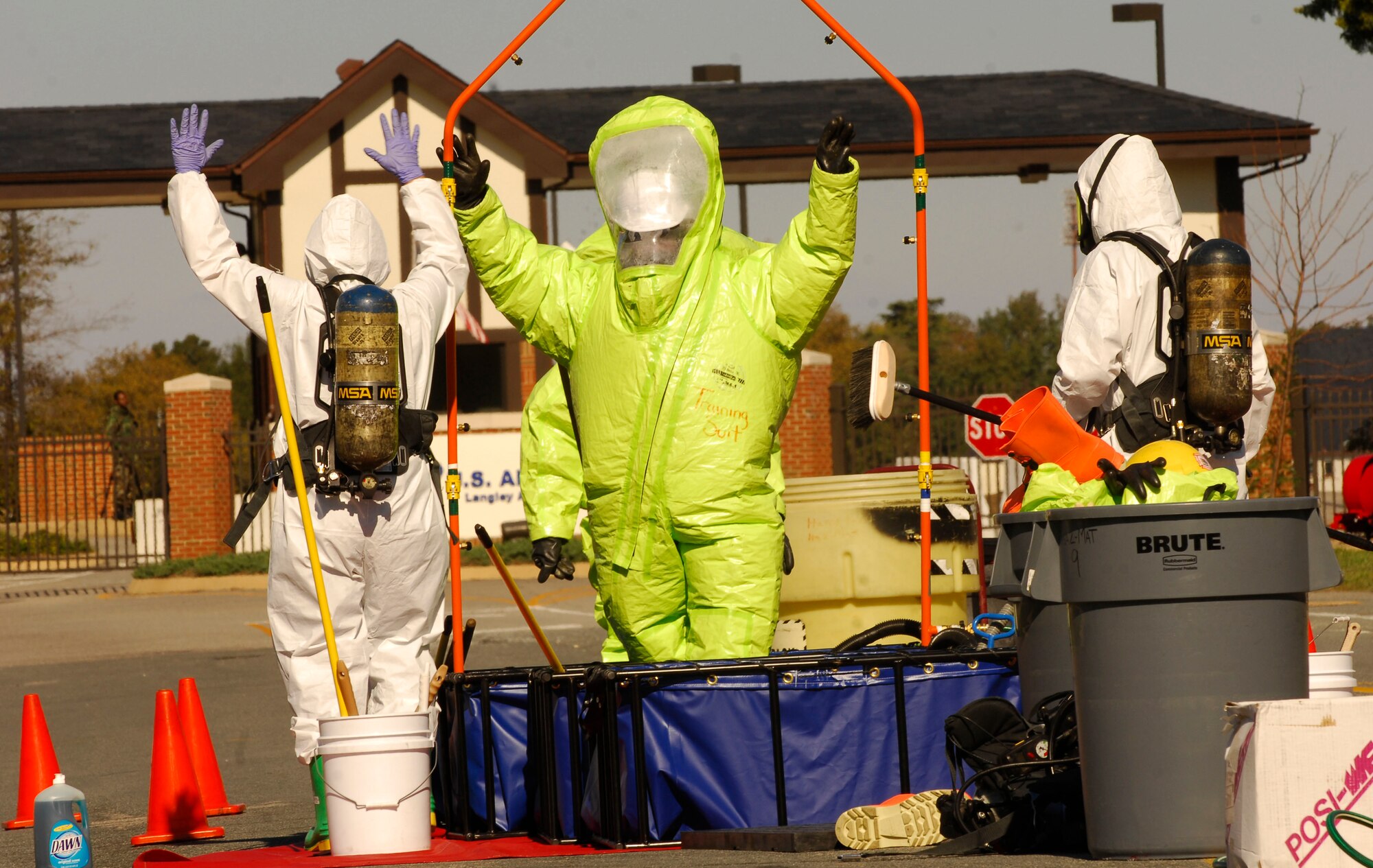 LANGLEY AFB, Va. -- Fred Schmid (center)  , a medic fire fighter with the Hampton Fire Department Hazmat Team, has his Class-A Ensembles  decontaminated by Joe Brown (left) and Lt. Jack Heckle (right) after containing a simulated chlorine spill during a Major Accident Response Exercise Nov. 7. The MARE was designed to test reaction and response times as well as the recovery process of Langley and local major accident response personnel if an environmental mishap were to take place on or near the installation. (U.S. Air Force Photo/Staff Sgt Samuel Rogers)