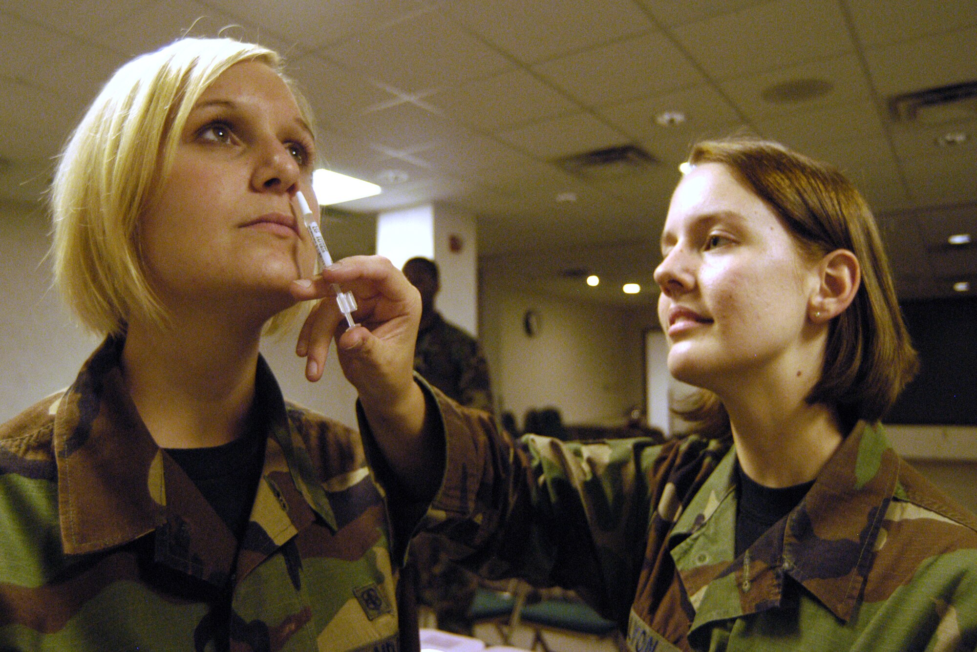 Airman 1st Class Penny Lyon, 436th Medical Operations Squadron medical technician, administers the Flumist (inactivated influenza vaccine) to Airman 1st Class Hayley Hagerud, 436th MDOS medical technician, Nov. 2 during deployment exercise preparations. (U.S. Air Force photo/Airman Shen-Chia Chu)                        