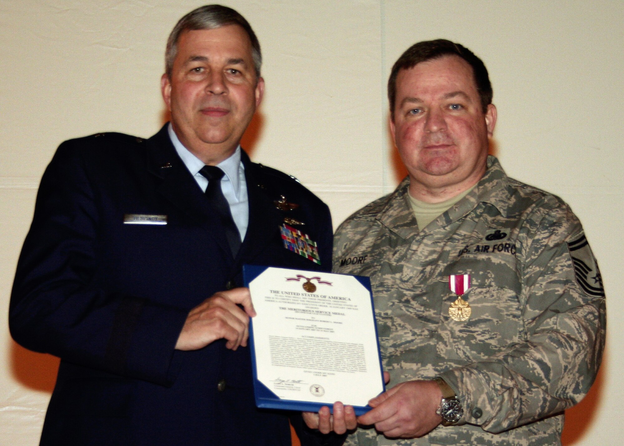 GRISSOM AIR RESERVE BASE, Ind., -- Brig. Gen. Dean Despinoy, left, 434th Air Refueling Wing commander, presents an Air Force Meritorious Service Medal to Senior Master Sgt. Robert Moore, 434th Logistics Readiness Squadron, during the wing commander's call held in November.  (U.S. Air Force photo/Tech. Sgt. Patrick Kuminecz)