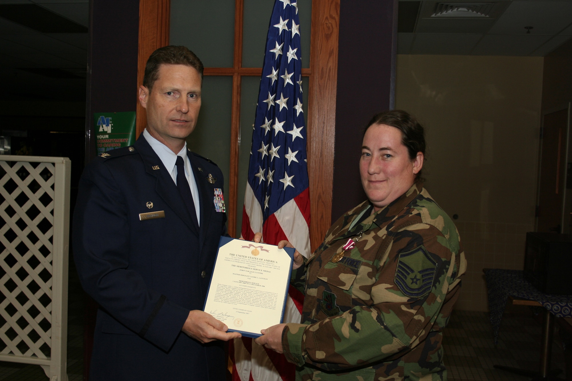 GRISSOM AIR RESERVE BASE, Ind., -- Col. Doug McHugh, 434th Mission Support Group commander, presents an Air Force Meritorious Service Medal to Master Sgt. Laurie Latchaw, 49th Aerial Port Flight, at a commander's call held during the November unit training assembly. (U.S. Air Force photo/Tech. Sgt. Patrick Kuminecz)