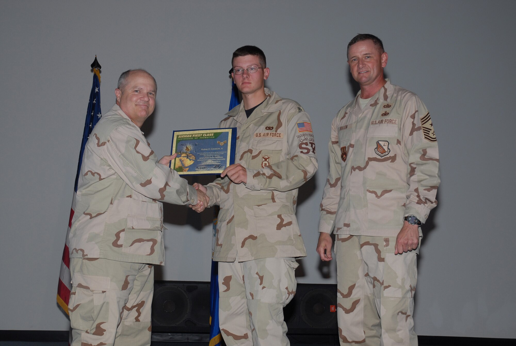 SOUTHWEST ASIA - Airman Rodney Colclasure (center), is promoted to the rank of Airman 1st class by Brig. Gen. Charlie Lyon (left), 379th Air Expeditionary Wing commander, during the Oct. 31 promotion ceremony. (U.S. Air Force photo by Staff Sgt. Douglas Olsen)