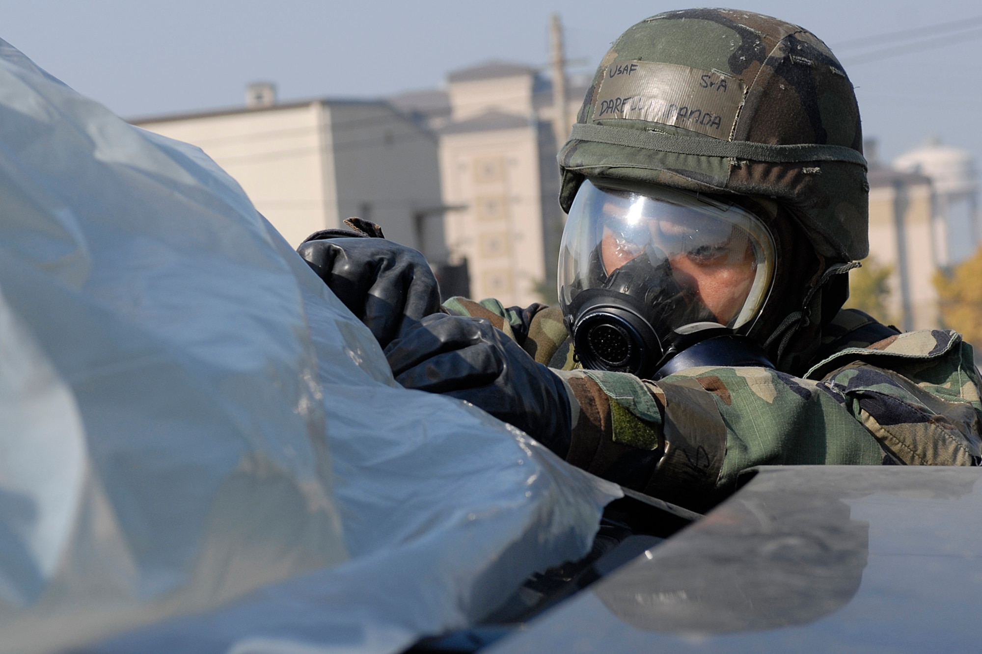 KUNSAN AIR BASE, South Korea --  Senior Airman Darrell Miranda, 8th Civil Engineer Squadron, covers up a vehicle with plastic wrapping to avoid contamination during a general release here Nov 8.  The Peninsula Operational Readiness exercise is conducted to ensure members of the Wolf Pack remain ready to execute its mission of "Defend the Base, Accept Follow on Forces and Take the Fight North." (U.S. Air Force photo/Senior Airman Giang Nguyen)
