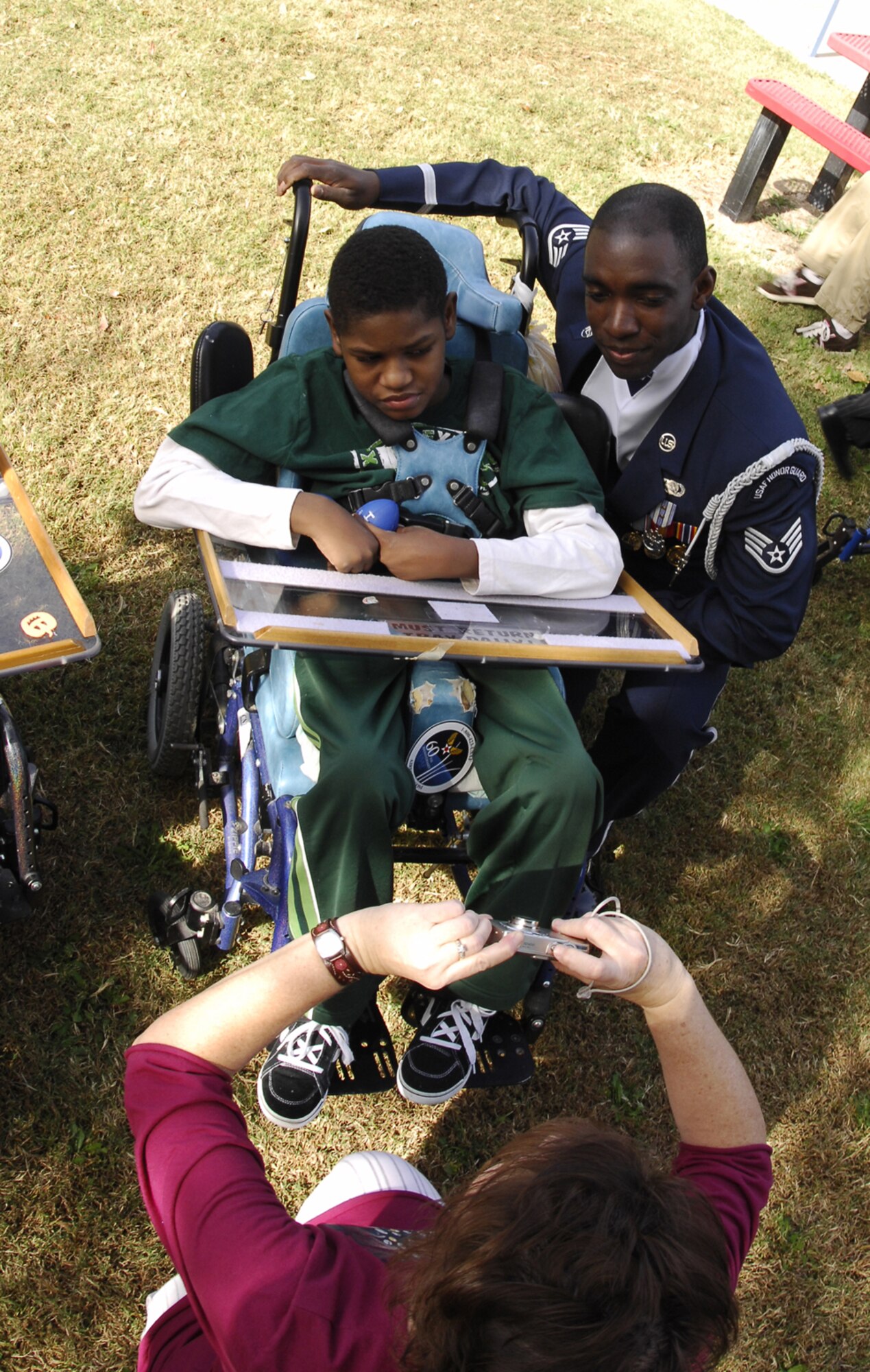 LAS VEGAS -- Staff Sgt. Taurean Lennon, Air Force Honor Guard Drill Team Operations NCOIC, poses for a picture with a student at the John F. Miller School for Special Needs Nov. 8.  The drill team planned a special performance for the students at the school during their visit to Las Vegas and Nellis Air Force Base, Nev., for the final week of the Air Force's 60th Anniversary celebrations.  (U.S. Air Force Photo by Airman 1st Class Alexander Montes)