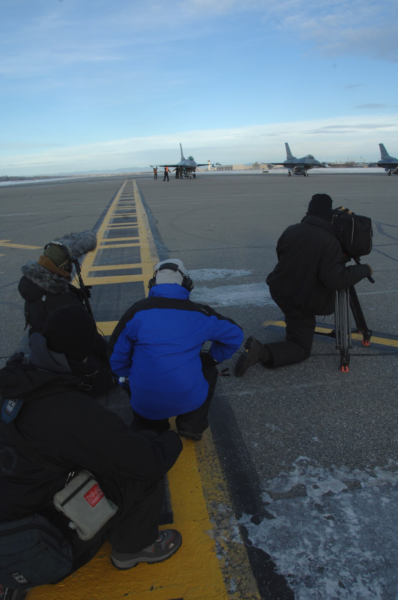 EIELSON AIR FORCE BASE, Alaska -- The Discovery Channel's television crew for the show Future Weapons observe as F-16 Fighting Falcons take off the Eielson flight line Nov. 7, 2007. The Future Weapons crew is visiting Eielson to document arctic survival training conducted by Det.1, 66th Training Squadron, otherwise known as "Cool School," and the Joint Precision Airdrop System being used under arctic conditions.  (U.S. Air Force photo by Airman 1st Class Christopher Griffin)