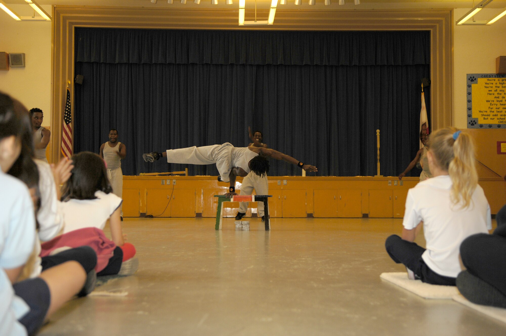 VANDENBERG AIR FORCE BASE, Calif. -- Amos Mwadzoya performs a one handed acrobatic balancing act during a show for kids at Crestview Elementary on Nov. 8.  Famous Africa Acrobats LLC., travels nationwide and their performances include the limbo, jump roping, summersaults, and human pyramids. (U.S. Air Force photo/Airman 1st Class Cole Presley)