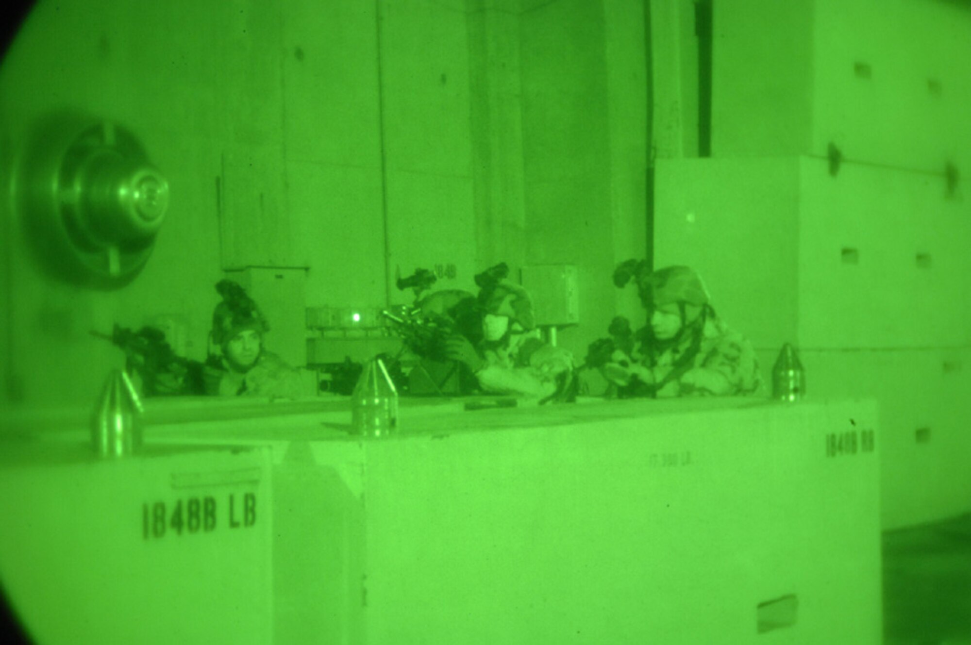 MINOT AIR FORCE BASE, N.D. -- Airmen from the 5th Security Forces Squadron take aim at the opposing force during a base exercise here, Nov. 8. Airmen from the 5th Munitions Squadron, role played the opposing force and simulated breaching a secure facility.  The security forces members were quickly able to meet their objective of regaining control of the building. (Photo by Airman 1st Class Cassandra Jones)