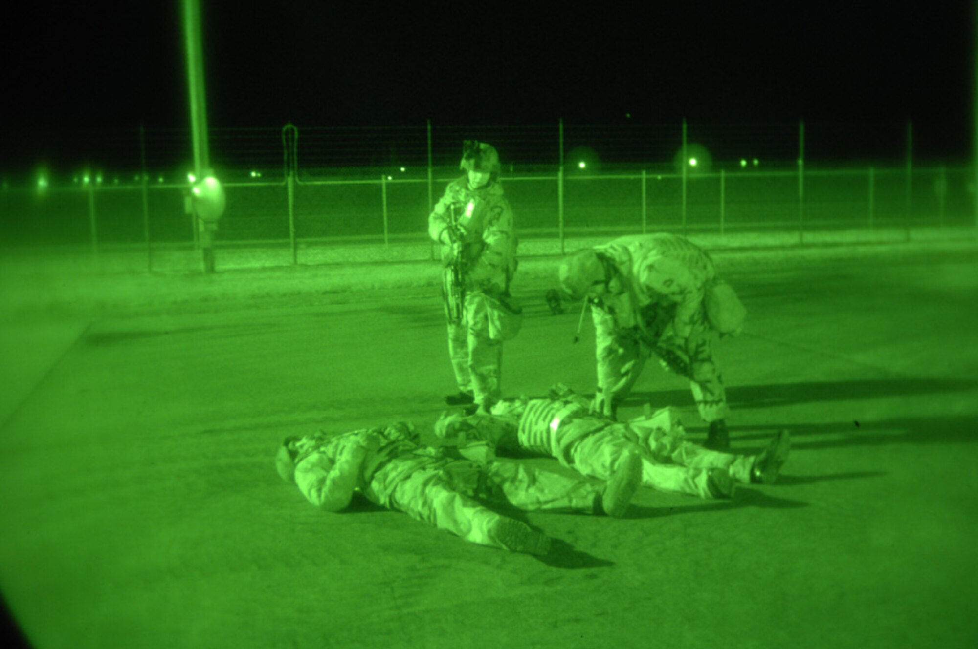 MINOT AIR FORCE BASE, N.D. -- Airmen from the 5th Security Forces Squadron check the "dead" bodies of the opposing forces killed in a simulated fire fight during a base exercise, here, Nov. 8. Bodies are checked to ensure there are no hidden explosive devices. (Photo by Airman 1st Class Cassandra Jones)