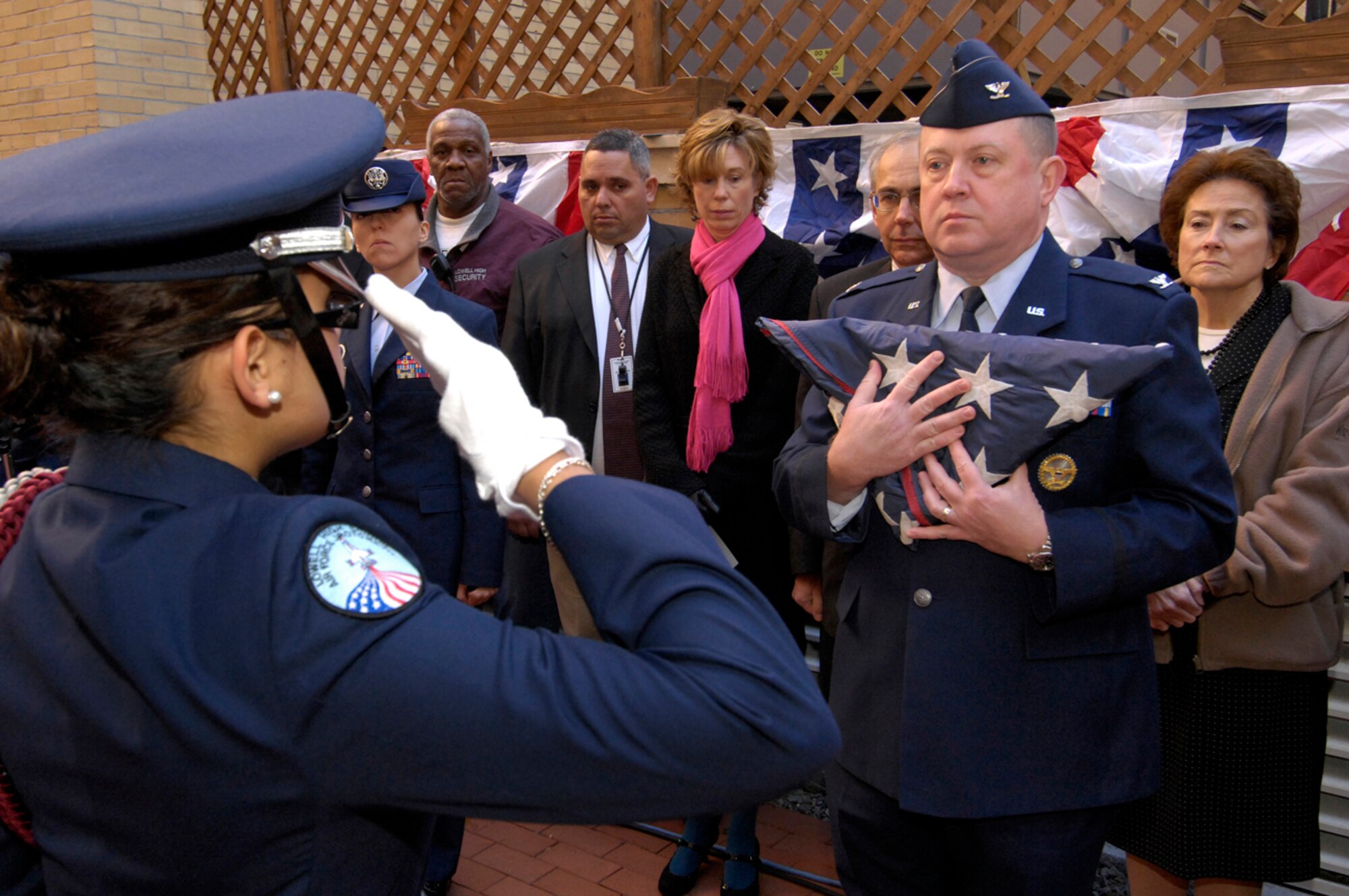 HANSCOM AFB, Mass. -- Cadet Natilia Guisa, Lowell High School student and member of Air Force Junior ROTC unit MA-771, salutes after presenting a folded U.S. flag to Col. Jeff Mayo, 66th Air Base Wing vice commander, during a Veterans Day remembrance event at Lowell High School in Lowell, Mass., on Nov. 8. (U.S. Air Force photo by Mark Wyatt)
