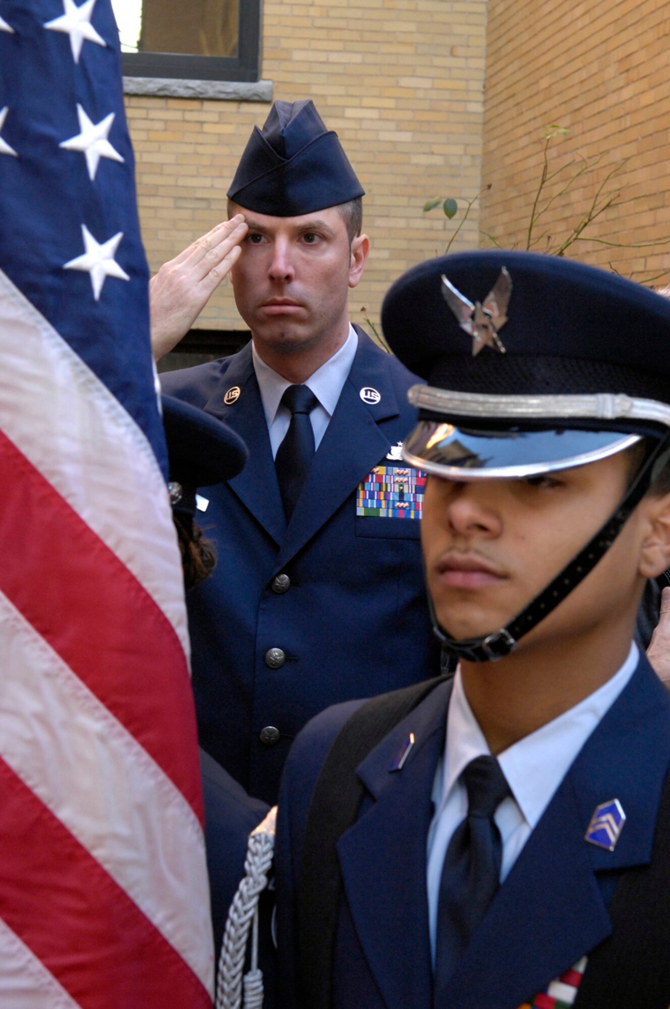HANSCOM AFB, Mass. -- Cadet Francis Leon, Lowell High School student and member of Air Force Junior ROTC unit MA-771, posts the U.S. flag while Tech. Sgt. Mike Dodge, 66th Air Base Wing, renders a salute during the playing of the National Anthem. A group of military personnel from Hanscom participated in the Junior ROTC unit’s Veterans Day remembrance event Nov. 8. Lowell High School in Lowell, Mass., boosts the only Junior ROTC unit that has presented the colors during the World Series; cadets from MA-771 did so in 2004 and 2007. Additionally, the MA-771 drill team has won first place honors in Greater New England Drill League competitions 12 years in a row. (U.S. Air Force photo by Mark Wyatt)
