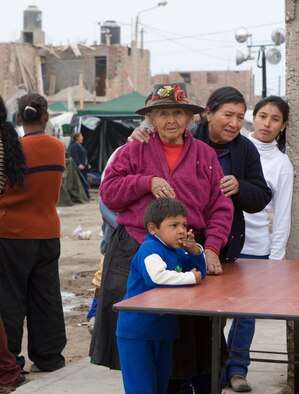 Victims of Peru's earthquake line up for medical assistance from the Air Force at Pisco, Peru.