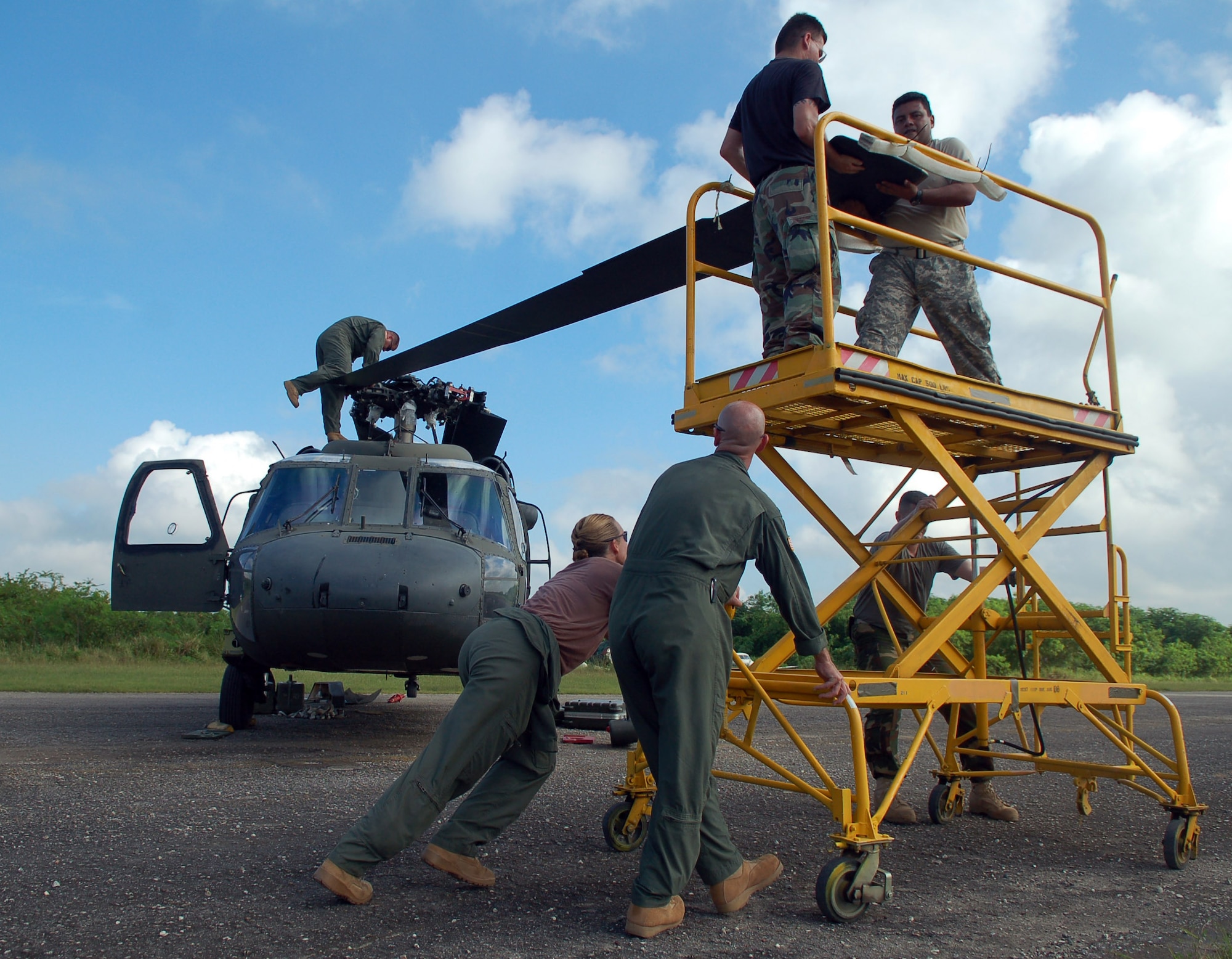 SAN ISIDRO AIR BASE, Dominican Republic -- A team of Soldiers and Airmen unfold the blades of an Army UH-60 Black Hawk helicopter in preparation for medical relief missions.  American servicemembers deployed from Joint Task Force-Bravo at Soto Cano Air Base, Honduras, to assist the Dominican Republic after it was ravaged by Tropical Storm Noel.  (U.S. Air Force photo by Staff Sgt. Austin M. May)