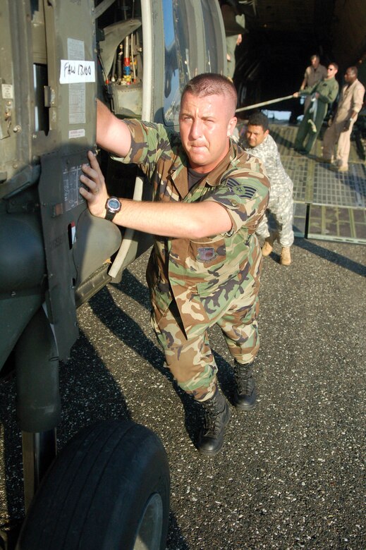 SAN ISIDRO AIR BASE, Dominican Republic -- Air Force Staff Sgt David Pagani, Joint Task Force-Bravo Medical Element, helps push an Army UH-60 Black Hawk helicopter out of an Air Force C-5 galaxy on the flight line here in preparation for medical relief missions.  American servicemembers deployed from Joint Task Force-Bravo at Soto Cano Air Base, Honduras, to assist the Dominican Republic after it was ravaged by Tropical Storm Noel.  (U.S. Air Force photo by Staff Sgt. Austin M. May)