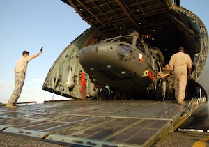 SAN ISIDRO AIR BASE, Dominican Republic -- The first of two Army UH-60 Black Hawk helicopters is unloaded from an Air Force C-5 Galaxy on the flight line here in preparation for medical relief missions.  American servicemembers deployed from Joint Task Force-Bravo at Soto Cano Air Base, Honduras, to assist the Dominican Republic after it was ravaged by Tropical Storm Noel.  (U.S. Air Force photo by Staff Sgt. Austin M. May)