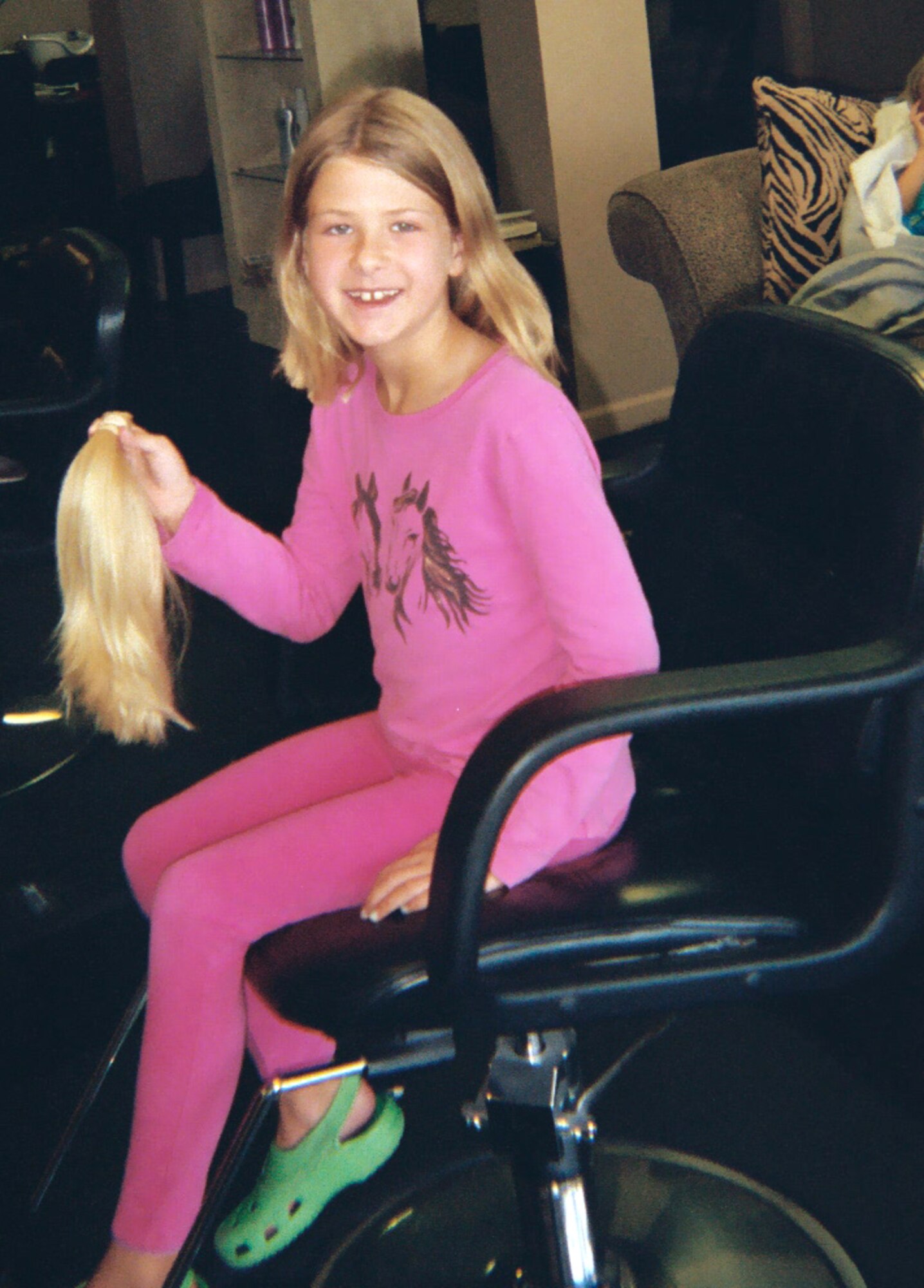 Katharine Omstead holds up her recently cut ponytail that she donated to "Locks of Love," an organization that makes wigs from donated hair for cancer paitients.  (Courtesy photo)