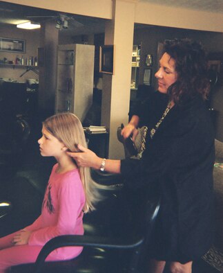 Katharine Omstead sits down in the stylist chair to get her ponytail cut to donate to "Locks of Love," an organization that makes wigs for cancer paitients.  (Courtesy photo)