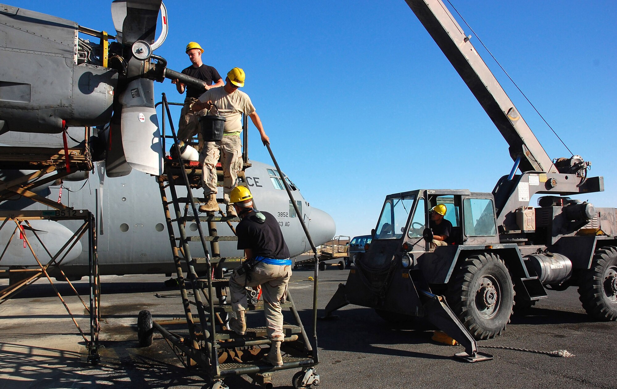 SOUTHWEST ASIA -- Airman 1st Class Joshua Kuzma (top), Staff Sgt Paul Ratliff (middle), Staff Sgt. Nathan Dickey (bottom), and Airman 1st Class Roy Rodriguez (right), all with the 386th Air Expeditionary Wing aerospace propulsion, work together during a C-130 Hercules propeller change Nov. 7 here.  The propeller was replaced due to a hydraulic leak in the blade pump housing. Sergeant Dickey is deployed from Pope AFB, N.C., Airman Kuzma is deployed from Yakota AB, Japan; Sergeant Ratliff and Airman Rodriguez are deployed from Ramstein AB, Germany.  (U.S. Air Force photo by Staff Sgt. Tia Schroeder)