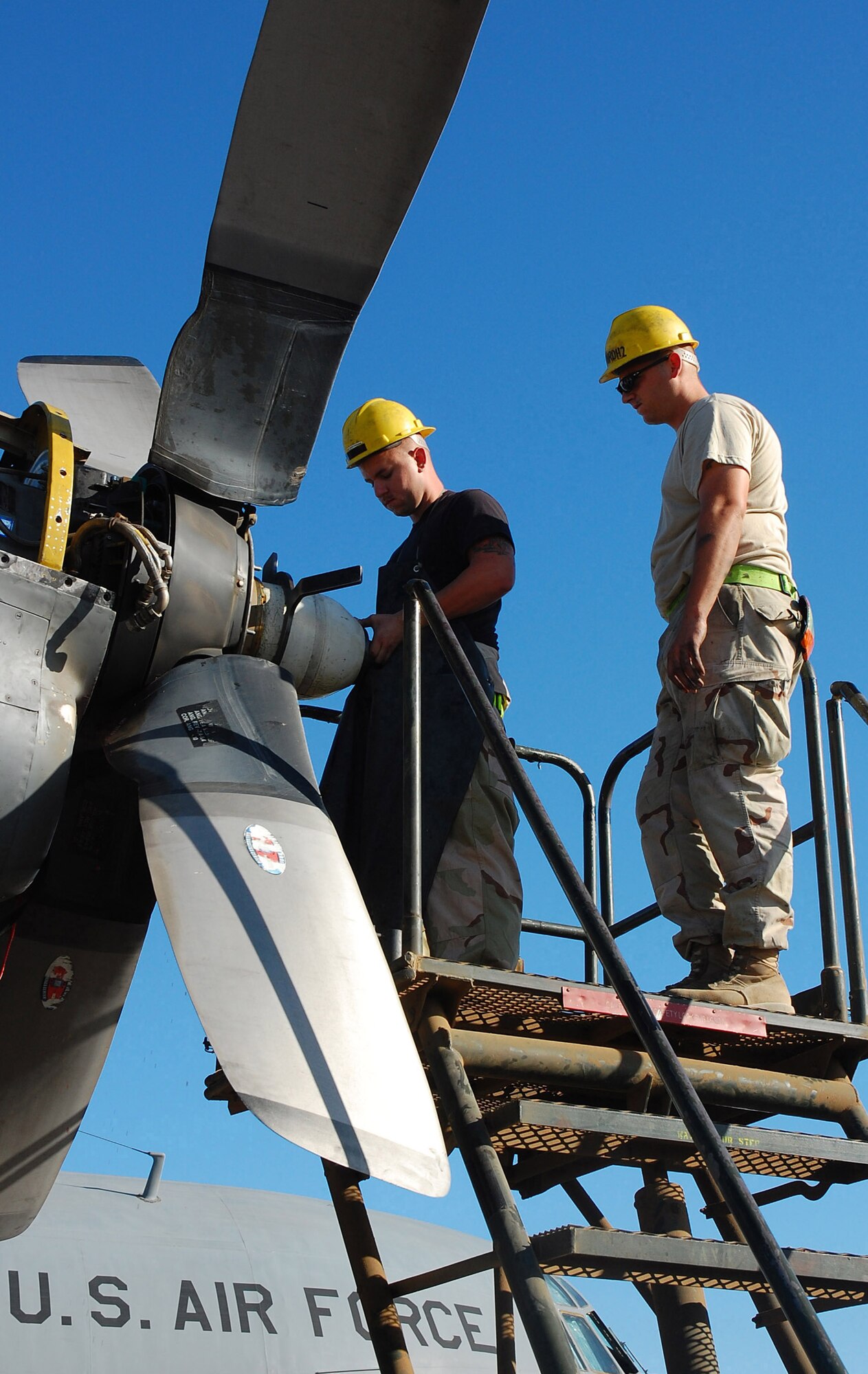 SOUTHWEST ASIA -- Airman 1st Class Joshua Kuzma (left) and Staff Sgt. Paul Ratliff (right), 386th Expeditionary Aircraft Maintenance Squadron aerospace propulsion specialists, perform a propeller change Nov. 7 here. The propeller was replaced due to a hydraulic leak in the blade pump housing.  Airman Kuzma is deployed from Yakota AB, Japan, and Sergeant Ratliff is deployed from Ramstein AB, Germany.  (U.S. Air Force photo by Staff Sgt. Tia Schroeder)