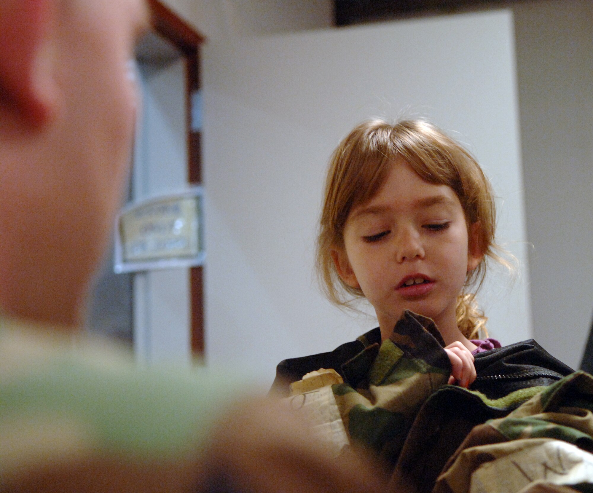 LANGLEY AIR FORCE BASE Va.--Emily Yankovich, daughter of Lt. Col. Joe Yankovich, tries on chemical warfare gear during Operation Hero. Operation Hero is a program designed to educated military children about deployments. (U.S. Air Force photo/Airman 1st Class Vernon Young)