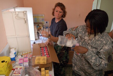 PAYA, Dominican Republic -- Air Force Captain Tracie Swingle and Army Sgt. Meredith Greene fill prescriptions Nov. 10 at a clinic set up by U.S. servicemembers from Joint Task Force-Bravo.  The pair are part of an Expeditionary Medical Liaison Team deployed to the Dominican Republic to provide medical assistance to the island nation.  (U.S. Air Force photo by Staff Sgt. Austin M. May)